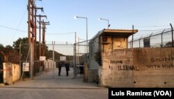 FILE - Police guard the entrance to the Moria migrant detention center at Lesbos, Greece, April 4, 2016.