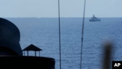 Sebuah kapal angkatan laut China berlayar di dekat kapal angkatan laut Filipina BRP Ramon Alcalaz PS16 dalam latihan militer yang dilakukan tentara Filipina di lepas pulau Loaita di laut China Selatan pada 6 November 2024. (Foto: AP/Aaron Favila)