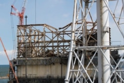 This photo shows the damaged Unit 1 reactor, back, and the exhaust stack shared with the Unit 1 and 2 reactors at the Fukushima Daiichi nuclear power plant in Okuma town, Fukushima prefecture, northeastern Japan, Feb. 27, 2021.
