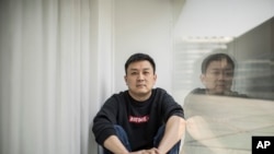 FILE - U.S. citizen Daniel Hsu poses for a portrait in the apartment he has been renting in Shanghai, China, April 13, 2020.
