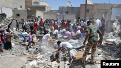 Men search for survivors amid debris of collapsed buildings after what activists said was an air raid by forces loyal to Syria's President Bashar al-Assad in Raqqa province, eastern Syria, August 10, 2013. 