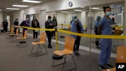 Healthcare workers wait in line to receive the Pfizer-BioNTech COVID-19 vaccine at Seton Medical Center in Daly City, Calif., Thursday, Dec. 24, 2020. (AP Photo/Jeff Chiu)