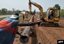 FILE - Workers of Ivory Coast Kuyo pipeline company assemble pipelines in Tiebissou, near Abidjan, the economical capital of Ivory Coast.