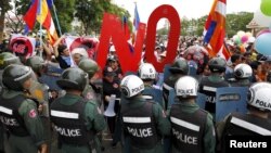 មន្ត្រី​ប៉ូលិស​បិទ​ផ្លូវ​​ខណៈ​ដែល​​បាតុករ​​ហែរ​ក្បួន​ទៅ​កាន់​រដ្ឋសភា​ជាតិ​កម្ពុជា ក្នុង​អំឡុង​ការ​តវ៉ា​មួយ​នៅ​រាជធានី​ភ្នំពេញ​កាល​ពី​ថ្ងៃ​ទី​១៣ ខែ​កក្កដា ឆ្នាំ​២០១៥។ កាល​ពី​ថ្ងៃ​ច័ន្ទ ប្រទេស​កម្ពុជា​បាន​​អនុម័ត​​ច្បាប់​ដ៏​ចម្រូងចម្រាស​ដើម្បី​គ្រប់គ្រង​អង្គការ​​ក្រៅ​រដ្ឋាភិបាល​​​ដែល​អ្នក​រិះ​គន់​និយាយ​ថា​នឹង​​បិទ​មាត់​ក្រុម​ប្រឆាំង។ REUTERS/Samrang Pring