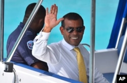 File - Maldives former President Mohamed Nasheed waves from a boat as he is taken back to Dhoonidhoo prison after a court dismissed his appeal against his arrest in Male, March 2015.