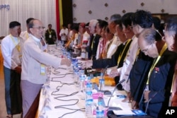 Myanmar President Thein Sein, front left, greets representatives of political parties during a meeting at Yangon region government office in Yangon, Myanmar, Nov. 15, 2015.