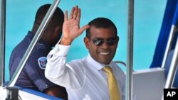 File - Maldives former President Mohamed Nasheed waves from a boat as he is taken back to Dhoonidhoo prison after a court dismissed his appeal against his arrest in Male, Maldives, March 2015.