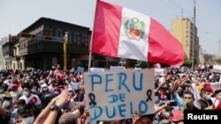 Les Péruviens réagissent dans la rue après que le président intérimaire Manuel Merino a annoncé sa démission, à Lima, au Pérou, le 15 novembre 2020. 