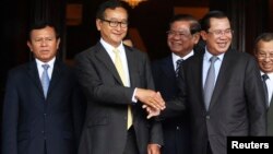លោក​​​នាយក​​​រដ្ឋ​​​មន្ត្រី​​​ ហ៊ុន​​​ សែន​​​ កំពុង​​​ចាប់​​​ដៃ​​​គ្នា​​​ជាមួយ​​​លោក​​​​​​ សម​​​ រង្ស៊ី​​​ ប្រធាន​​​គណបក្ស​​​សង្គ្រោះ​​​ជាតិ​​​ បន្ទាប់​​​ពី​​​កិច្ច​​​ប្រជុំ​​​នៅ​​​មន្ទីរ​​​ព្រឹទ្ធ​​​សភា​​​​​​ នឹង​​​ឈាន​​​ដល់​​​ការ​​​បញ្ចប់​​​វិបត្តិ​​​ជាប់​​​គាំង​​​នយោបាយ​​​នៅ​​​កម្ពុជា​​​​​​ពី​​​ថ្ងៃ​​​ទី​ ២២​​​ ខែ​​​កក្កដា​​​ ឆ្នាំ​​​២០១៤​​​។​​​ REUTERS/Stringer