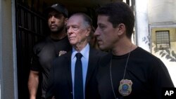 Carlos Nuzman, President of the Brazilian Olympic Committee, center, is escorted by federal police officers after being taken into custody at his home, in Rio de Janeiro, Brazil, Oct. 5, 2017.