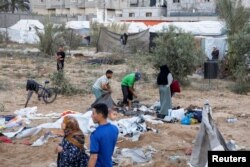 가자지구 남부 라파의 팔레스타인 난민들이 천막 더미를 뒤지고 있다.