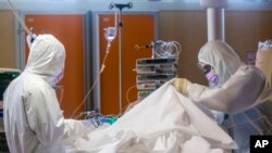 Medical staff of the Intensive Care Unit of the Casalpalocco COVID-19 Clinic in the outskirts of Rome tend to patients, Wednesday, March 25, 2020.