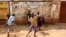 FILE - Children play in the street in Kisenyi, a slum in Kampala.