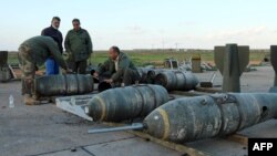 Libyan soldiers loyal to Libya's internationally recognized government work next to bombs at the Benina air base on Dec. 10, 2015, south of the eastern coastal city of Benghazi. 