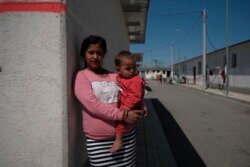 Xhensila Bukri menggendong putranya Arben Bukri di Tirana, Albania. Xhensila menikah pada usia 12 tahun dan sekarang enam tahun kemudian memiliki tiga anak. (Foto: VOA)