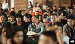 FILE - Undocumented people wait to fill out application forms for the Deferred Action for Childhood Arrivals program at Navy Pier in Chicago, Illinois, Aug. 15, 2012.