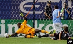 FILE -- D.C. United goalkeeper Bilal "Bill" Hamid, left, stops a shot on the goal.