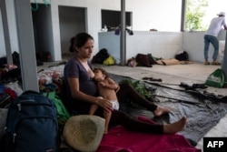 Sandra Aracely Gutierrez, 22, a pregnant Honduran migrant, part of a caravan heading to the U.S., breastfeeds her daughter in downtown San Pedro Tapanatepec, Oaxaca State, Mexico, Oct. 28, 2018.