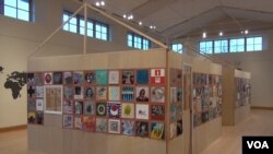 A big house structure contains 300 panels on which artists have depicted their immigrant ancestors showing the diversity and inclusivity of the U.S. (JSoh/VOA)