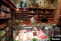 Owners of a Syrian grocery shop pack foodstuffs as a group of Hungarians, on an organized tour to learn about Budapest's Muslim community, visit the shop in Budapest, Hungary, Nov. 3, 2017.