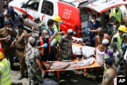 Petugas datang di lokasi untuk mengankat korban yang hancur terinjak-injak dalam kerumunan massa saat melaksanakan ibadah haji tahunan di Mina, 24 September 2015.