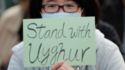 In this Dec. 22, 2019, file photo, a man holds a sign during a rally to show support for Uighurs and their fight for human rights in Hong Kong. (AP Photo/Lee Jin-man, File)