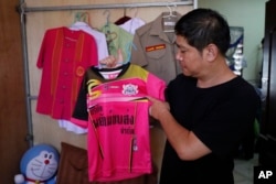 Banphot Konkum, father of Duangpetch Promthep, shows his son's soccer jersey during an interview at their home in Mae Sai district, Chiang Rai province, northern Thailand, July 13, 2018.