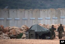 Israeli soldiers, right, serve near the Israel-Lebanon border where the army is digging to look for tunnels from Lebanon in the northern Israeli town of Metula, Dec. 19, 2018.