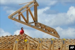 FILE - In this July 17, 2014 photo, construction workers build a commercial complex in Springfield, Ill.