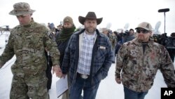 FILE - Ammon Bundy, center, walks off after speaking with reporters during a news conference at Malheur National Wildlife Refuge headquarters Jan. 4, 2016, near Burns, Oregon.