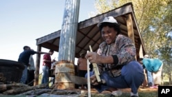 Rev. Grace Akunor of Ghana chops wood to burn in a hand-made, efficient, clean-burning cook stoves constructed from mud bricks, a safer alternative to open fires that cause 1.6 million deaths annually in the world's poorest countries.