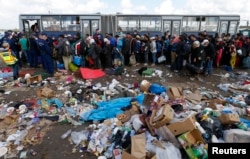Migrants wait to board a bus at a migrant collection point in Roszke, Hungary, Sept. 12, 2015.