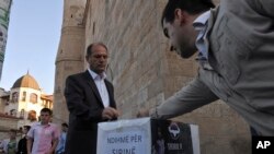FILE - Kosovo Muslims donate money in a box labeled "Help for Syria" in front of the Grand Mosque in Kosovo's capital Pristina in this 2012.