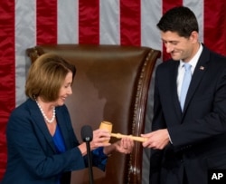 FILE - Newly-elected House Speaker Paul Ryan receives the Speaker's gavel from House Minority Leader Nancy Pelosi, in the House Chamber on Capitol Hill in Washington, Oct. 29, 2015.