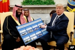 FILE - President Donald Trump shows a chart highlighting arms sales to Saudi Arabia during a meeting with Saudi Crown Prince Mohammed bin Salman in the Oval Office of the White House, March 20, 2018, in Washington.