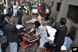 People help victims of a bomb blast in Quetta, Pakistan, Monday, Aug. 8, 2016.