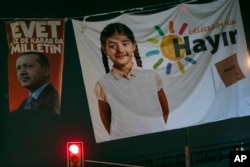 FILE - Posters of Turkey's President Recep Tayyip Erdogan, left, and the NO (Hayir in Turkish) campaign, right, for the upcoming referendum, are seen in Istanbul, March 27, 2017.