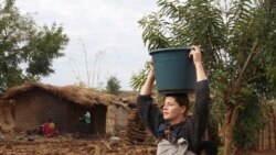 Cameron Beach, carries a carries a container of water on her head collected from a communal water gathering site in Dedza, near Lilongwe, Malawi, Friday, July 23, 2021. (AP Photo/Roy Nkosi)