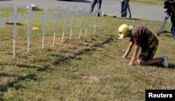 Brandy Jones prays in front of 26 crosses erected near the site of the shooting at the First Baptist Church of Sutherland, Texas, Nov. 6, 2017.