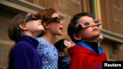 Children wear protective glasses as they try to view a partial solar eclipse from Observatory Hill in Sydney, Australia in 2014.