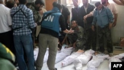 Handout photo released by Syrian opposition's Shaam News Network shows UN observers at hospital morgue before their burial in central Syrian town of Houla on May 26, 2012.