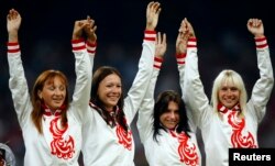 FILE - Gold medalists, Russia's women's 4x100 relay team Evgeniya Polyakova, Aleksandra Fedoriva, Yulia Gushchina, Yuliya Chermoshanskaya pose during the medal ceremony of the athletics competition in the National Stadium at the Beijing 2008 Olympic Games, Aug. 23, 2008.