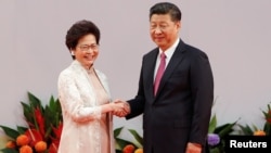 FILE - Hong Kong Chief Executive Carrie Lam shakes hands with Chinese President Xi Jinping after she swore an oath of office on the 20th anniversary of the city's handover from British to Chinese rule, in Hong Kong, China, July 1, 2017.