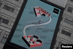 FILE - An electronic billboard advertising Uber is seen in front of an office block in London, June 28, 2017.