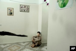 In this July 25, 2018, photo, 14 year-old Abdel Majeed sits on the floor at a rehabilitation center for former child soldiers in Marib, Yemen.