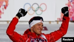 Winner Switzerland's Dario Cologna celebrates during a flower ceremony for the men's 15 km cross-country classic event at the Sochi 2014 Winter Olympic Games in Rosa Khutor, Feb. 14, 2014.