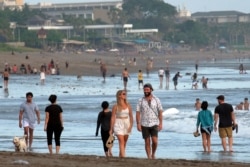Turis berjalan di pantai saat pemerintah memperpanjang pembatasan untuk mengekang penyebaran COVID-19 di Badung, Bali, 9 September 2021. (Foto: Antara/Nyoman Hendra Wibowo via REUTERS)