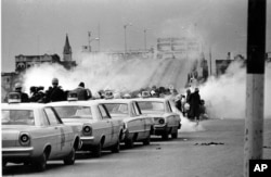 FILE - Tear gas fumes fill the air as state troopers, ordered by Gov. George Wallace, break up a demonstration march in Selma, Ala., on what is known as Bloody Sunday on March 7, 1965.