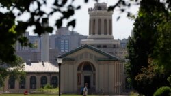 FILE - In this file photo from June 7, 2019, a man walks by Hamerschlag Hall on the Carnegie Mellon University in Pittsburgh. Colleges in the U.S. saw a drop among international students in the fall of 2020. (AP Photo/Gene J. Puskar, File)