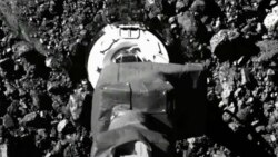 In this image taken from video released by NASA, the Osiris-Rex spacecraft touches the surface of asteroid Bennu on Tuesday, Oct. 20, 2020. (NASA via AP)